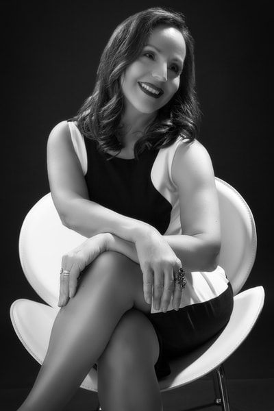 Woman sitting in a white leather chair in a vintage glamour photography photo