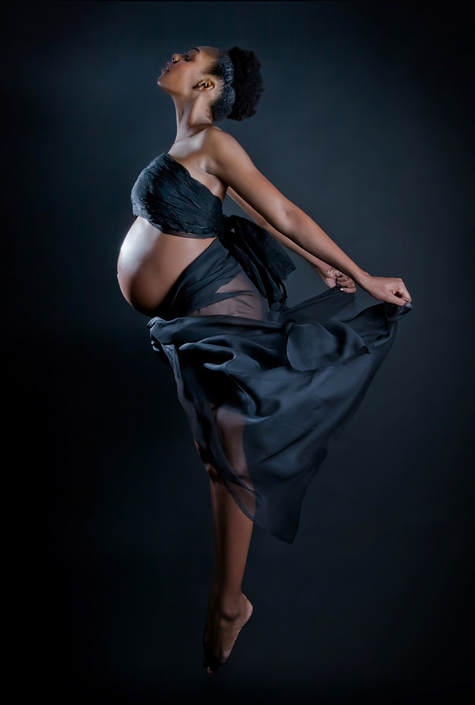 8 month pregnant woman jumping in mid-air during a maternity boudoir shoot with Las Vegas pregnancy photographer Bryan Kurz
