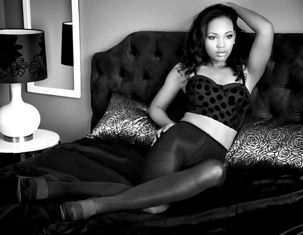 Black and white boudoir photo of a beautiful young woman in a boudoir photography pose