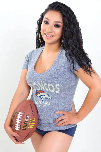 Curvy woman posing with a football wearing a Denver Broncos jersey