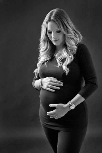 Maternity photographer photo of a young pregnant woman holding her belly