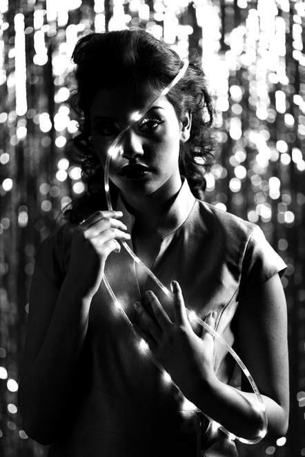 Glamor portrait of a young female posing with LED lights during a fashion photo shoot