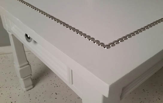 Furniture tacks hammered into the nightstand 