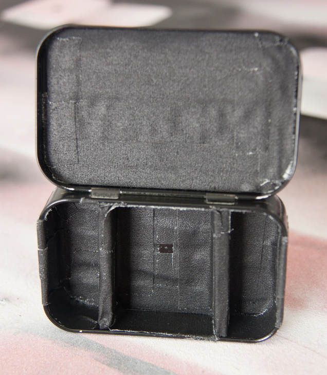 Inside of a DIY pinhole camera made from an Altoids tin