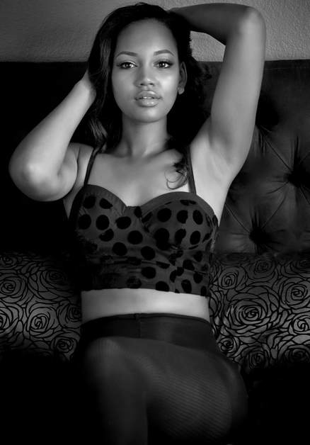 black and whit boudoir photography of a young woman posing on a bed