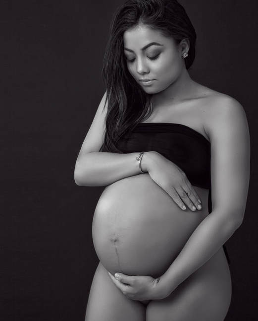 Pregnancy photo of a mother to be holding her large pregnant belly