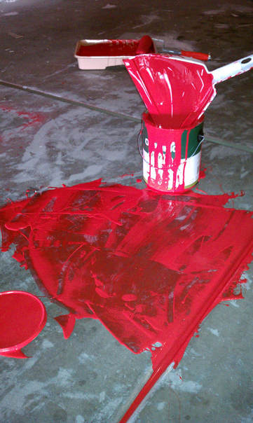 Spilled red paint on garage floor of studio makeover