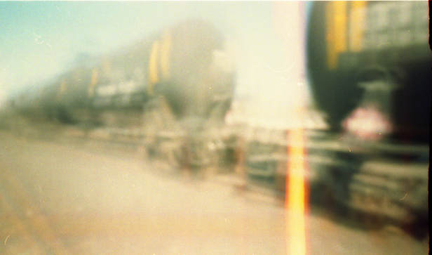 A photo of a train taken with a pinhole camera made from an Altoids tin box
